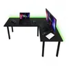 A black L-shaped gaming desk with a laptop, monitor, keyboard, and mice. Green LED lighting is visible behind the desk. Produktbild-Vorschau