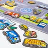 A collection of colorful, cartoon-like magnets shaped like vehicles and road elements, arranged on a surface that resembles a road map. Produktbild-Vorschau