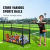 A boy is holding a ball next to a ball storage cart on a sports field. Produktbild-Vorschau