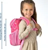 A young girl wearing a beige dress and a pink backpack. Anteprima dell’immagine prodotto
