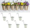A collage of two images. The top image shows decorative flower pots hanging on a wall. The bottom image shows six individual metal buckets with handles. Produktbild-Vorschau