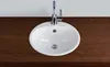 A white sink with a chrome faucet is installed on a dark wooden countertop. Produktbild-Vorschau