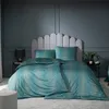 A bedroom scene with a bed dressed in teal bedding with a gold pattern, against a dark gray paneled wall. Produktbild-Vorschau