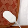 A close-up view of an electric blanket's control unit and textured fabric. Produktbild-Vorschau
