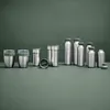 A collection of stainless steel thermoses and cups with green lids, arranged on a green surface against a green background. Voir les images du produit