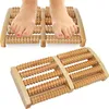 A pair of feet resting on a wooden foot massager. Náhľad obrázku produktu