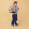 A young girl wearing a backpack and jeans, posing for a photo. Produktbild-Vorschau
