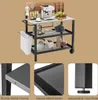 A kitchen cart with various items on it, shown from a slightly elevated angle. The cart has multiple shelves and is equipped with a trash bag holder and wheels. Small inset images highlight specific features of the cart. Náhled obrázku produktu