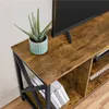 A close-up view of a rustic-style TV stand with a potted plant and books. Podgląd zdjęcia produktu