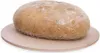 A round loaf of bread sits on a light-colored, round pizza stone. Podgląd zdjęcia produktu