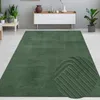 A green rug with a geometric arc pattern is shown in a living room setting. Podgląd zdjęcia produktu