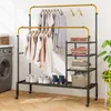 A laundry room with a washing machine and a rolling garment rack filled with clothes and shoes. Anteprima dell’immagine prodotto