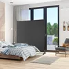 A bedroom scene with a bed, a room divider, and a chair. Náhled obrázku produktu