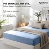 A bedroom scene with a bed made with a light blue fitted sheet and beige pillows. Produktbild-Vorschau