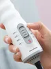 A close-up shot of a hand adjusting the temperature control on a white hair dryer. Náhled obrázku produktu