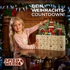 A young girl is standing next to a wooden advent calendar decorated with a Christmas village scene. Produktbild-Vorschau