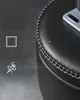 Close-up of a black faux leather stool with visible stitching and a phone on top. Náhled obrázku produktu