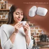 A woman is smelling a cup of coffee in a kitchen setting, with coffee filters superimposed. Produktbild-Vorschau