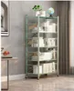 A tall, green, multi-shelf unit filled with books and decorative items, placed in a room with a grey wall and a window with curtains. Produktbild-Vorschau