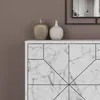 A close-up view of a marble cabinet with two decorative vases on top, against a brown wall. Náhled obrázku produktu