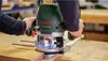 A person is using a Bosch router on a wooden surface. Anteprima dell’immagine prodotto