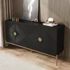 A black sideboard with gold accents is displayed in a room with a textured wall and wooden floor. Produktbild-Vorschau