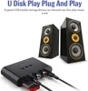 A black audio adapter is shown in the foreground with two black speakers in the background. Text overlays describe the product's features. Produktbild-Vorschau