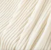 A close-up view of a cream-colored, ribbed blanket. Podgląd zdjęcia produktu