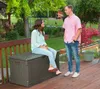 A couple is talking on a wooden deck next to a garden. Produktbild-Vorschau