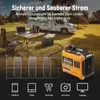 A portable generator is set up outdoors next to a table with a laptop and coffee maker, with a camper van in the background. Produktbild-Vorschau
