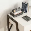 A close-up view of a desk with a stack of books, a digital clock, a smartphone, and a notebook. Podgląd zdjęcia produktu