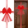 A red tulle bow with gold accents is shown both on a white background and attached to a wooden door. Náhled obrázku produktu