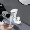 Hands being washed under a white waterfall faucet in a modern bathroom. Podgląd zdjęcia produktu