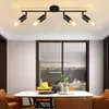 A modern dining room with a black ceiling light fixture above a marble-topped dining table. Voir les images du produit
