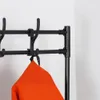 A close-up of a black metal coat rack with an orange garment hanging on it. Náhled obrázku produktu