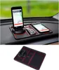 Schwarze und rote rutschfeste Auto-Armaturenbrett-Matte mit integriertem drehbarem Handyhalter, gezeigt mit zwei Smartphones und einem Autoschlüssel, sowie einer separaten Ansicht der Matte allein Náhľad obrázku produktu