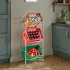A three-tiered storage rack filled with drinks and fruit in a kitchen setting. Náhled obrázku produktu
