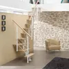 A modern staircase with wooden steps and white railings in a room with a stone wall and a chair. Produktbild-Vorschau