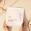 Hands holding a pouch of Glow25 Collagen Plus powder, with a wooden spoon and a bowl of yogurt in the background. Produktbild-Vorschau