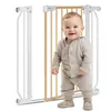 A baby stands in front of a baby gate. Náhled obrázku produktu
