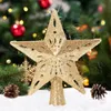 A golden star-shaped tree topper sits on a snowy surface in front of a decorated Christmas tree. Produktbild-Vorschau