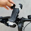 A hand is shown attaching a black Wozinsky phone holder to a bicycle handlebar. Produktbild-Vorschau