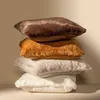 A stack of four square pillows with different textures and colors, arranged vertically against a plain background. Produktbild-Vorschau