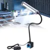 A magnetic LED work light is shown attached to a metal surface, illuminating a laser cutting machine in operation. Podgląd zdjęcia produktu