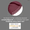A close-up of a burgundy fabric with a decorative edge, overlaid with text and a certification logo. Náhled obrázku produktu