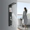 A woman in a bathrobe stands in a modern bathroom, looking out a large window. A black shower panel with water flowing is in the foreground. Náhľad obrázku produktu