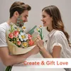A couple is holding a bouquet of artificial flowers and smiling at each other. Produktbild-Vorschau