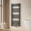 A modern bathroom with a towel radiator, a stool with a towel, and a bathtub. Anteprima dell’immagine prodotto