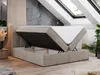A bedroom with a boxspring bed with storage, featuring a mattress that is lifted to reveal the storage compartment. The room has a modern, minimalist design with a sloped ceiling and skylights. Produktbild-Vorschau