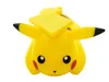 A yellow Pikachu toy with black accents on its ears and eyes, and red cheeks, is shown from a front-facing angle against a white background. It has yellow square-shaped objects on its head. Produktbild-Vorschau